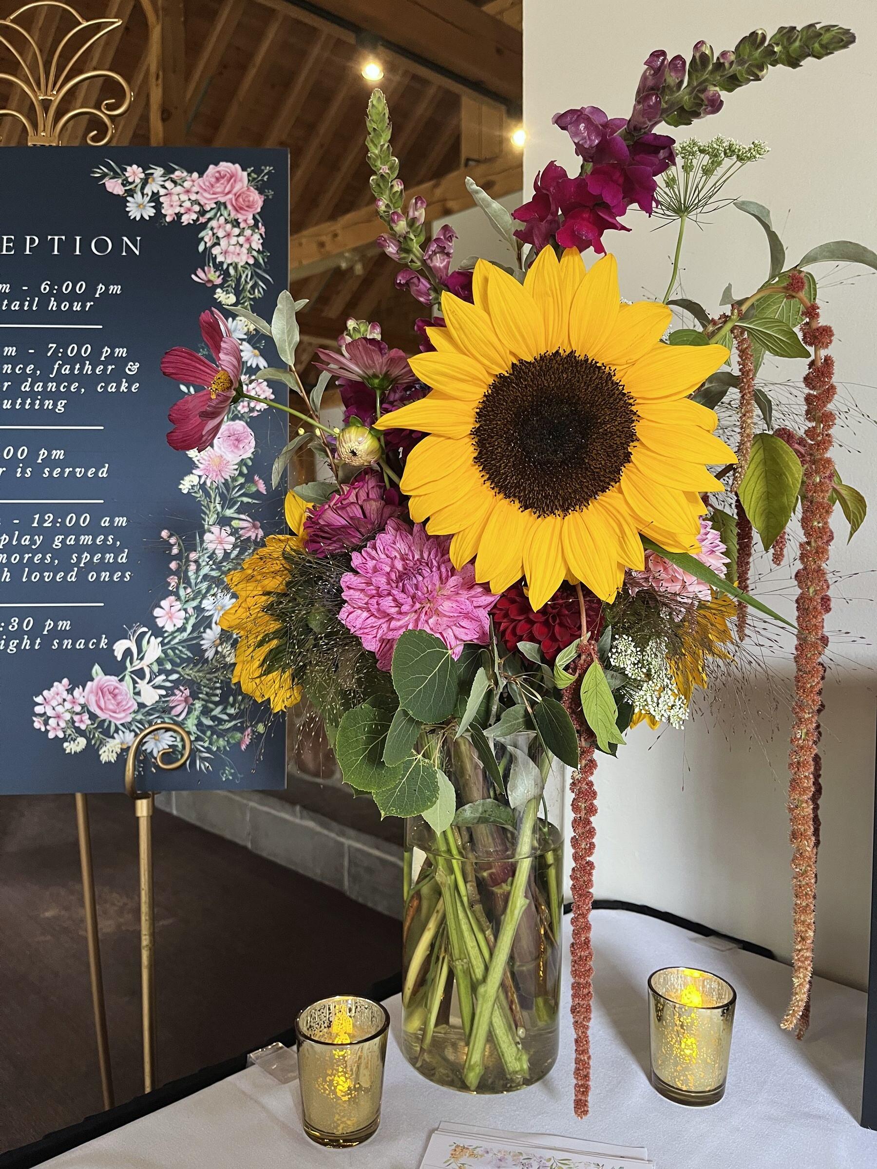 Sunflower arrangement beside a reception welcome sign